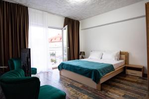 a bedroom with a bed and a chair and a window at 5 Bedrooms Luxury Apartment Villa in Bucharest