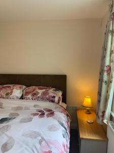 a bedroom with a bed and a table with a lamp at Brimsmore Apartment in Yeovil