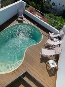 a swimming pool on top of a deck with chairs at Casa S’Arraval in Mahón