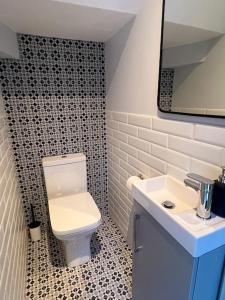 a bathroom with a white toilet and a sink at Modern 2 Bed House With EV Parking in Henwick