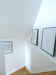 坎佩尔Le Cottage的白色的楼梯,上面有三幅画框