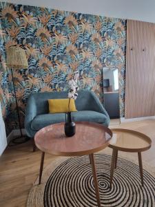 坎佩尔Le Cottage的客厅里有一张蓝色的沙发和一张桌子