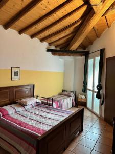 two beds in a bedroom with wooden ceilings at Agriturismo La Rasdora in Porto Mantovano