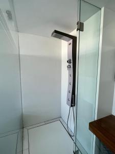 uma cabina de duche ao nível do chão com uma porta de vidro em Modern seafront apartment em Limassol