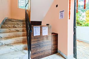 a staircase in a house with a glass door at Super Hotel O Shree Residency in Thākurdwari