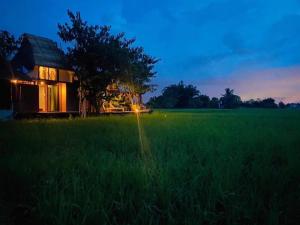 a house in the middle of a grass field at Ideal View Villa lanna in Ban Pa Lan