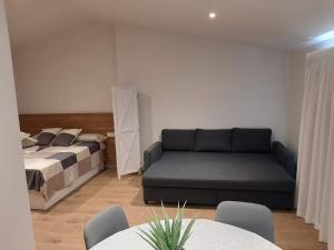 uma sala de estar com uma cama e um sofá em Apartaments Vall del Corb 1 Garrotxa 