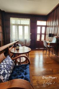 a living room with a couch and a table at V1-Baan Borijinda-Wooden House in The old city of Chiang Mai in Chiang Mai