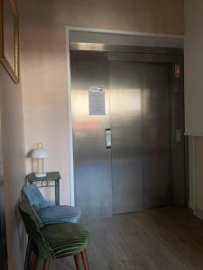 einen Aufzug mit einem blauen Stuhl neben einer Tür in der Unterkunft Le Grand Hôtel Ussel ''nouvelle Gérance 2023'' in Ussel