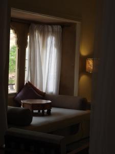 a living room with a couch and a window at The Stepwell Hotel in Jodhpur