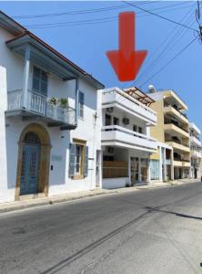 a red cross on top of a building on a street at Noer Hostel in Larnaka