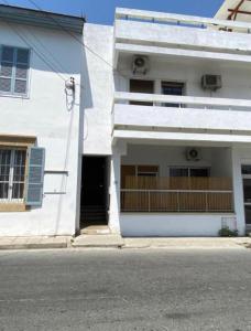 a white building on the side of a street at Noer Hostel in Larnaka