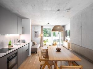 una cucina e un soggiorno con tavolo in legno di BASECAMP Reiteralm a Schladming