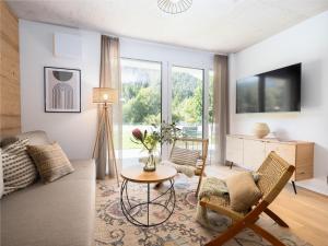 a living room with a table and chairs and a tv at BASECAMP Reiteralm in Pichl