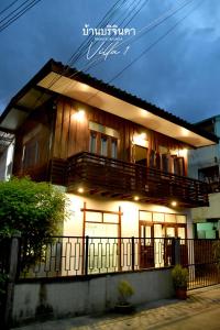 a house with a balcony with lights on it at V1-Baan Borijinda-Wooden House in The old city of Chiang Mai in Chiang Mai