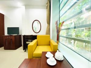 胡志明市的住宿－Cozi 5 Serviced Apartment，客厅配有黄色椅子和桌子