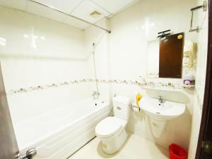 胡志明市的住宿－Cozi 5 Serviced Apartment，白色的浴室设有卫生间和水槽。