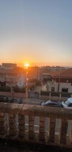 a sunset over a city with buildings and boats at Habitación sencilla con balcón in Vigo