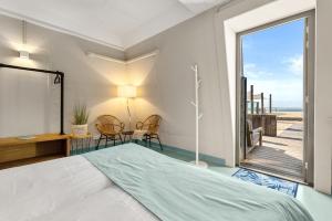 Schlafzimmer mit einem Bett und Meerblick in der Unterkunft Beachrooms Pier 7 in Vlissingen