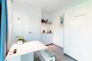 un ufficio bianco con una scrivania bianca e una porta di Le Betulle Studios by Quokka 360 - studio apartments by the Origlio lake a Origlio
