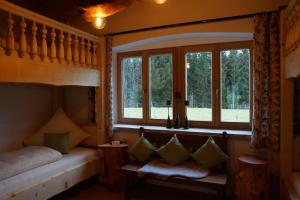 Schlafzimmer mit einem Bett, einem Fenster und einer Bank in der Unterkunft Chalet Bauer in Drachselsried