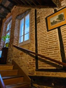 un edificio de ladrillo con escaleras y una ventana en Sous les toits du vieux Cahors en Cahors