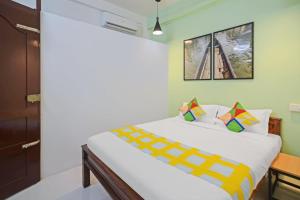 - une chambre avec un grand lit blanc et une fenêtre dans l'établissement OYO Home Pop Tavern Pettah, à Chacka