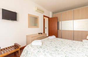 ein Schlafzimmer mit einem Bett und einem TV an der Wand in der Unterkunft Casty Sweet Home - parcheggio privato gratuito in Mailand