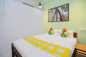 a bedroom with a large white bed in a room at OYO Home Pop Tavern Pettah in Chacka