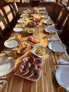 una larga mesa de madera con platos de comida. en 7Rooms, en Telnice