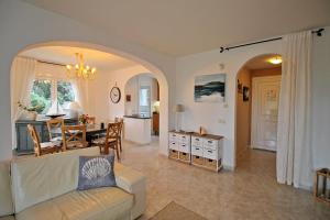 Villa Blanca في كالونج: غرفة معيشة مع أريكة وغرفة طعام