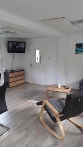 ein Wohnzimmer mit einem Stuhl und einem Tisch in der Unterkunft Bergheim in Bad Elster