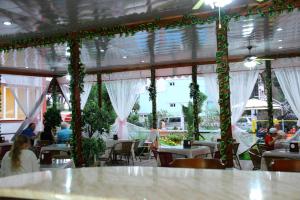 a restaurant with white curtains and people sitting at tables at Hotel Exotica in Ureki