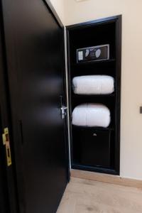 a bathroom with a black door with a stack of towels at Ennesma Hotel in Casablanca