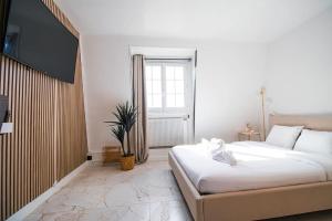 ein Schlafzimmer mit einem großen weißen Bett und einem Fenster in der Unterkunft Typical Parisian Studio in Le Marais in Paris + 10 Fotos