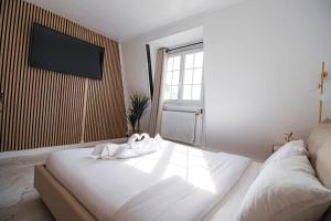 1 dormitorio con 1 cama y TV en la pared en Typical Parisian Studio in Le Marais en París
