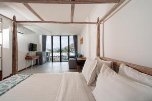 a bedroom with a bed and a living room at Komodo Suites Downtown Managed by CPM Bali in Labuan Bajo