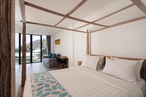 a bedroom with a bed and a large window at Komodo Suites Downtown Managed by CPM Bali in Labuan Bajo