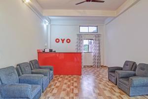 uma sala de espera com duas cadeiras e uma porta vermelha em SPOT ON Jp Guest House em Kāhārpāra