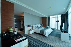 マナーマにあるRamee Grand Hotel And Spaのベッドとテレビが備わるホテルルームです。