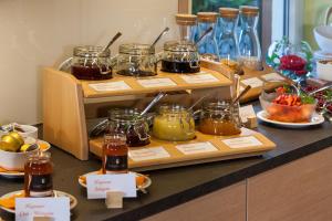 a buffet with jars of honey and other food at Hotel Mohren in Hagnau +73 photos