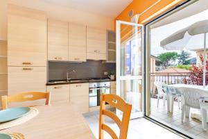 a kitchen and dining room with a table and chairs at Appartamento Minerva int3 - MyHo Casa in Tortoreto Lido