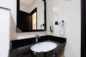 een badkamer met een wastafel en een spiegel bij Ennesma Hotel in Casablanca