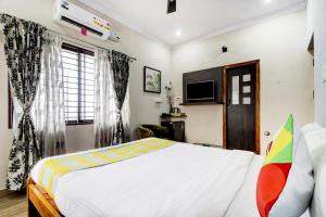 a bedroom with a large bed and a tv at Home Vp Inn in Vānivilāsa Puram