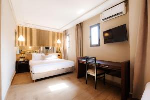 una camera d'albergo con letto e scrivania di Ennesma Hotel a Casablanca