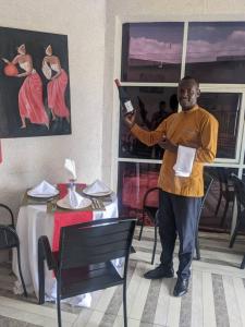 a man standing in a restaurant holding a knife at AVISHA TOWN HOTEL in Kigali