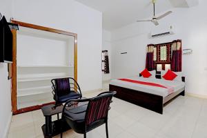 um quarto com uma cama e uma cadeira em OYO K B Residency em Chennai