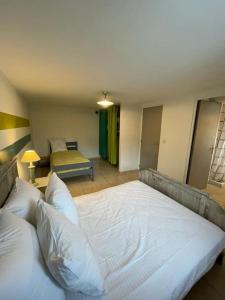 a bedroom with a large white bed in a room at Appartement paisible près des pistes de ski 4 pers in Fontrabiouse