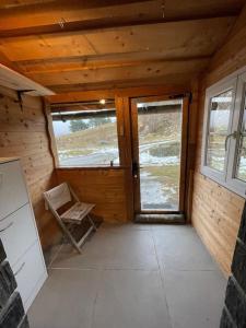 a room with a door and a chair in a cabin at Appartement paisible près des pistes de ski 4 pers in Fontrabiouse +2 photos