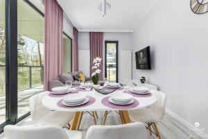 a dining room with a white table and white chairs at Shellter Apartments Villas - by Jantar Apartamenty in Rogowo